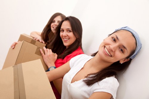 Apartment removal team handling furniture in a narrow stairwell in Hackneymarshes